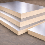 Gestapelde PIR isolatieplaten met gladde aluminium toplaag op betonnen ondergrond.